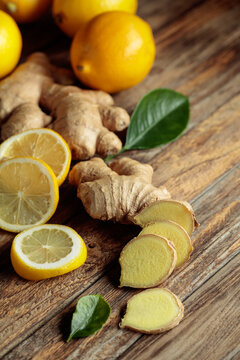 Ginger roots and fresh lemons on an old wooden table.