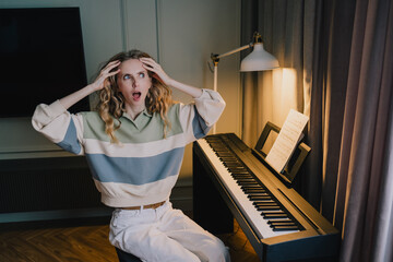 Frustrated woman reacting to difficulty while learning and practicing piano at home © VK Studio