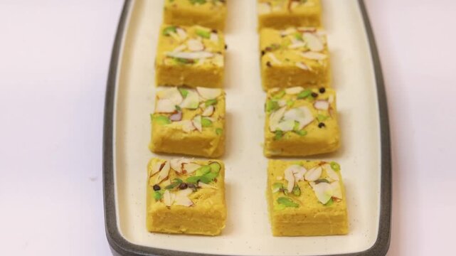 Soan papdi garnished with dry fruits plated on white plate