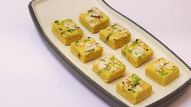 Soan papdi garnished with dry fruits plated on white plate