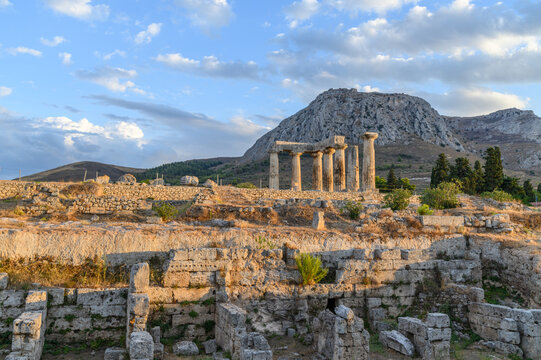 Temple of Apollo glowing in the golden evening light below Acrocorinth, Ancient Corinth, Greece