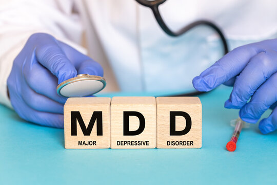 Clinical depression awareness and psychiatry medical concept. Doctor hands over MDD acronym on blue background