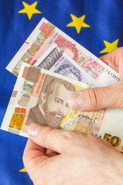 Bulgaria money. Real Bulgarian lev held in hand against European Union flag background. Financial concept. Emotions after changing the currency in Bulgaria. Vertical photo.
