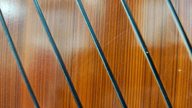 Polished teak boat deck surface with black caulking seams in diagonal pattern