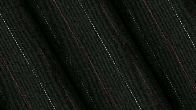 Dynamic spinning rolls of Italian charcoal pinstripe wool silk fabric showing subtle luster and professional executive suiting material for tailoring