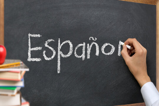 Hand writing Espanol on a classroom blackboard
