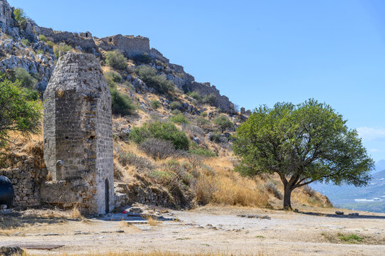 Tapered stone tower below the fortress walls climbing the ridge of Acrocorinth, Corinthia, Greece