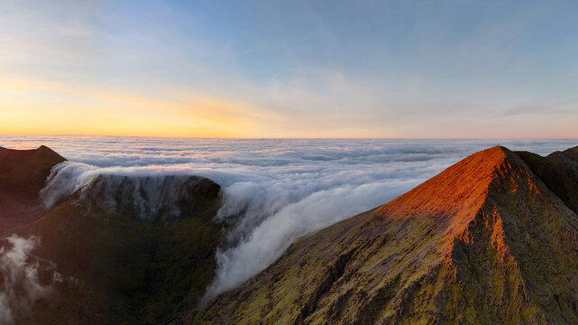 Breathtaking aerial view of Carrauntoohil and Devil's Ladder with cloud inversion at sunrise in MacGillycuddy's Reeks, County Kerry, Ireland