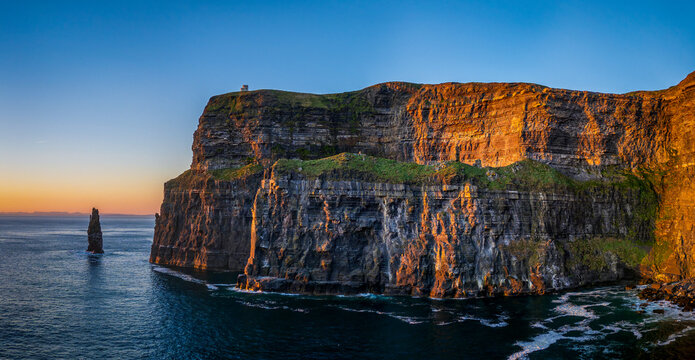 Panoramic view of the sea stack Branaunmore at the dramatic Cliffs of Moher during golden hour sunset in County Clare, Ireland