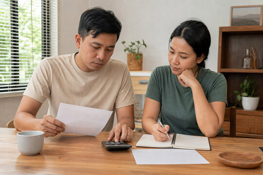 Asian partners calmly discussing reduced income after a job change