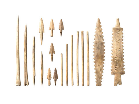 Ancient prehistoric carved bone tools and arrowheads arranged neatly on surface