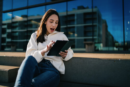 Side view of woman holding smartphone and looking away thoughtfully at bus stop, career growth, ambition, digital nomad life, urban architecture background, copy space, modern connectivity.