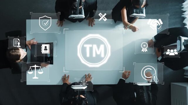A top-down view of a business team collaborating on digital strategy, featuring technology icons and a trademark symbol, showcasing innovation and property management. Raster