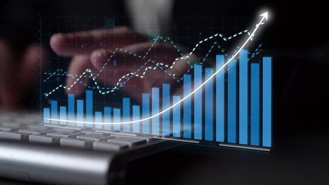 A close-up view of a digital growth chart on a computer screen with hands typing on a keyboard, illustrating business success and financial analysis in a modern workspace. Copula
