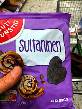 FRANKFURT, GERMANY - AUGUST 23, 2026: Person Holding Edeka Brand Sultanas Bag in Supermarket