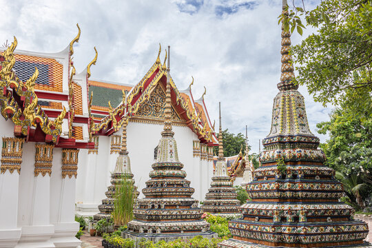 Das Bild zeigt kunstvoll verzierte Chedis (Stupas) und die Architektur des buddhistischen Tempelkomplexes Wat Pho in Bangkok, Thailand