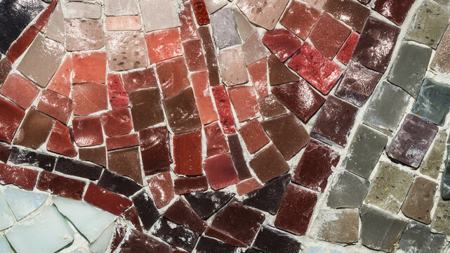 Dense mosaic texture with red terracotta and grey stone tiles