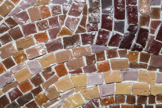 Macro of earthy brown and beige ceramic mosaic tiles with varied shapes