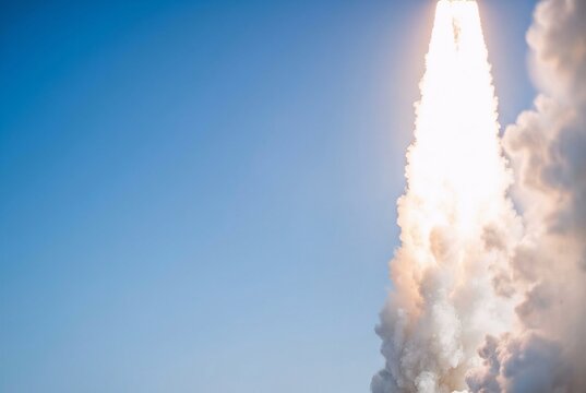 Wide angle shot of a bright white rocket plume on the right. Smooth daylight blue sky on the left. Cinematic haze for bright web banner layouts.