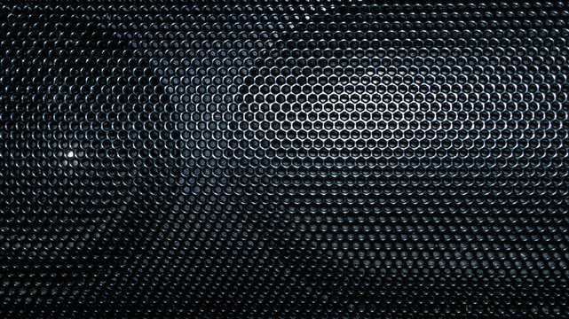 Black perforated metal speaker grille with hexagonal pattern abstract background