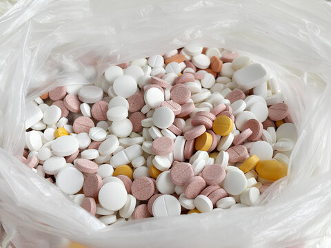 Pile of expired pills with a variety of colorful tablets in a bag