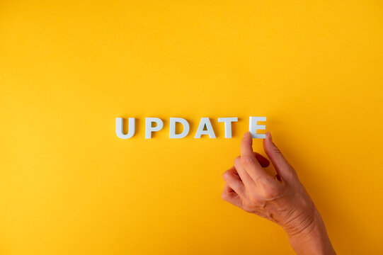 Update and upgrade concept with hand arranging UPDATE letters