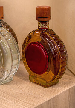 Traditional alcohol brandy liquor in decorative glass bottle on wooden desk at home