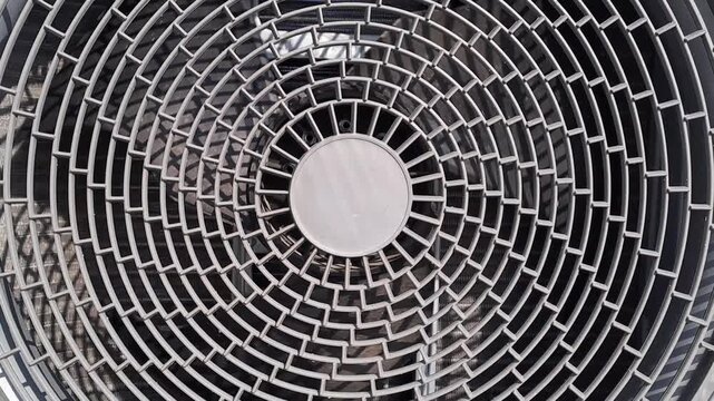 Symmetrical flat lay close-up of a circular geometric metal grille pattern on an air conditioner unit. Industrial technology stock video footage.