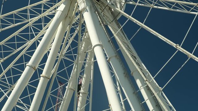 A view of a large ferris wheel structure against a blue sky 