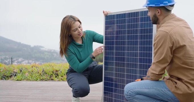 African American technician and client placing solar panel, steadying panel on roof, aligning cells