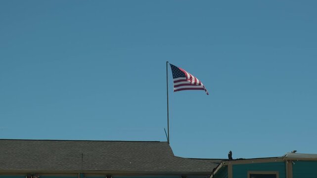 american flag waving on a building under clear blue sky