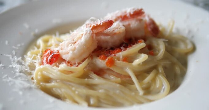Close up of creamy fettuccine Alfredo pasta with shrimp and grated parmesan cheese