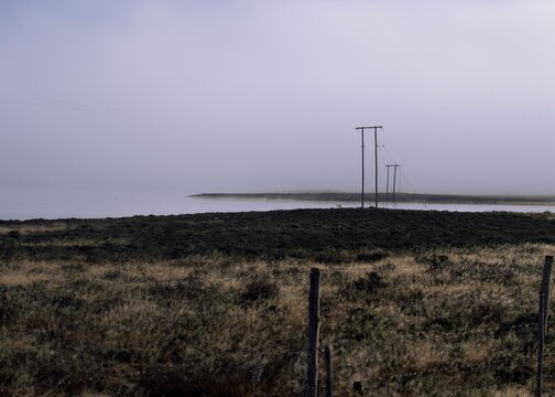 Power lines over the lake in the fog