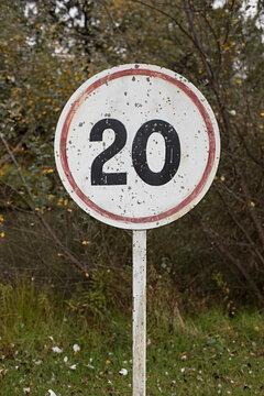 Old weathered sign with 20 hand painted on roadside 