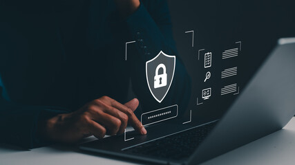 Person using a laptop with a digital shield and password icon, symbolizing cybersecurity and data protection. © waragron