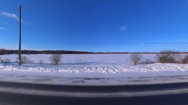 Point of view of car side view driving plate in Innisfil town in Ontario, Canada high way. Travelling in February winter snowy road. Travel and destination to lake Simcoe for Ice fishing.