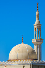 Traditional mosque dome and minaret against clear blue sky © Buğra Kaan Ersoy