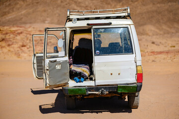 Rear view of an old white offroad vehicle parked in the desert with open doors © Buğra Kaan Ersoy