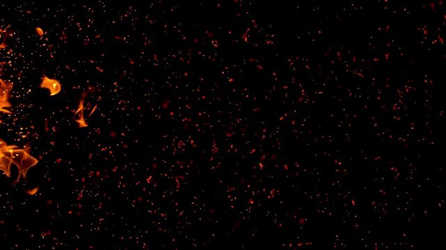 Sparks flew, coals ignited in the flames. Abstract glowing flame and smoke particles on black background, campfire flame burning
