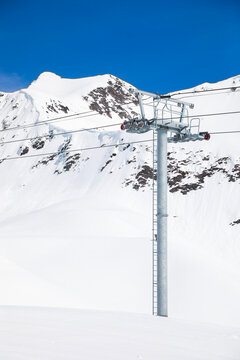 ski lift tower and cable on snowy mountain
