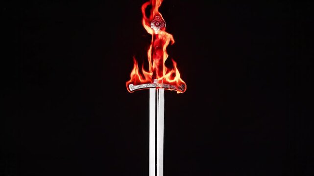Medieval Sword Hilt Engulfed in Flames on Black Background