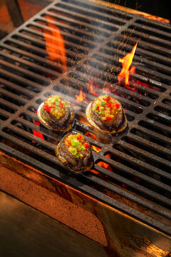 High-speed shutter shot of flames grilling seafood, oysters, and fish.
