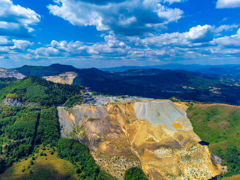 Aerial view of a tailings dump spilled into the mountains, resulting from the Rosia Poieni copper quarry in the Apuseni Mountains - Romania