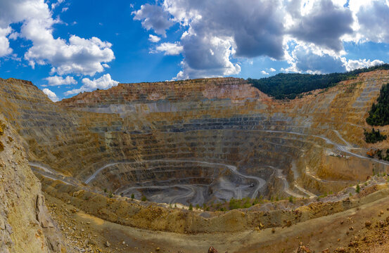 Rosia Poieni copper mine, a massive open pit excavation located in the Apuseni Mountains of Alba County, Transylvania, Romania. Terraced Rock Benches of the huge Surface Mine. Giant Open Pit Mine
