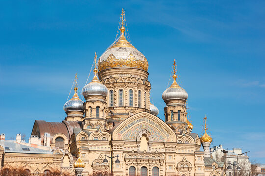 Golden and silver onion domes of the Assumption Church, compound of the Valaam Monastery in Saint Petersburg, rise against a clear blue sky, showcasing ornate Byzantine revival architecture and patter