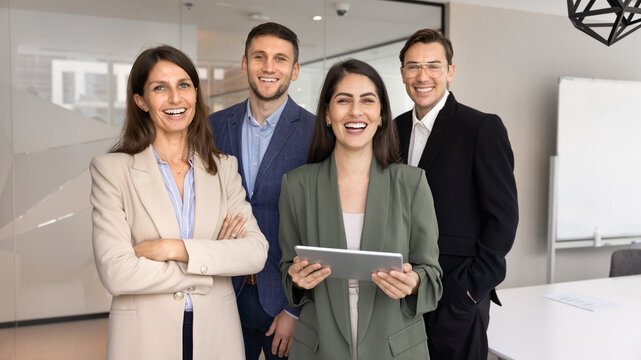 Confident diverse business team posing together for corporate branding portrait looking at camera with smiles representing modern professionals at work inclusive workplace culture office presentation