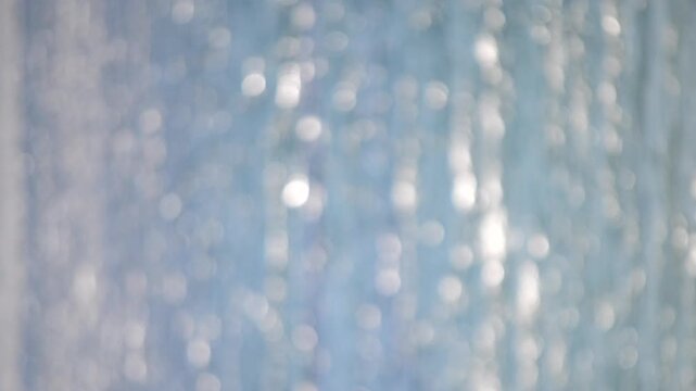 Sea. Blurred background. Abstract view of water surface of sea on sunny day with blurry white bokeh spots from sun glare on surface of sea. Natural abstract background. Sea sunny backdrop. Vertical