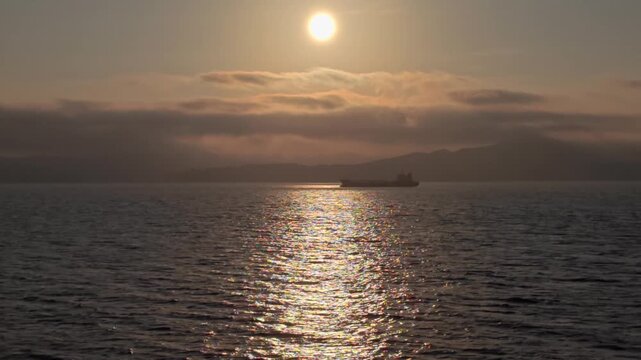 夕陽と船が見える海の風景。