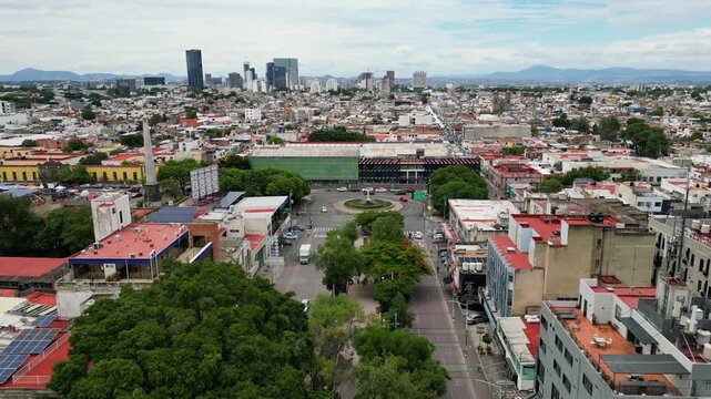 Cinematic aerial video flying above tree-lined Chapultepec Avenue heading toward Avenida Mexico in Guadalajara, Mexico