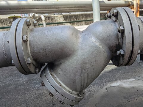 Heavy duty industrial Y-strainer pipe fitting with flanged connections in a chemical plant or oil refinery system.